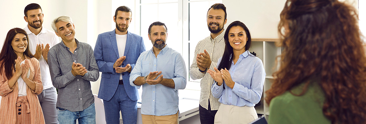 Equipe aplaudindo um colaborador.