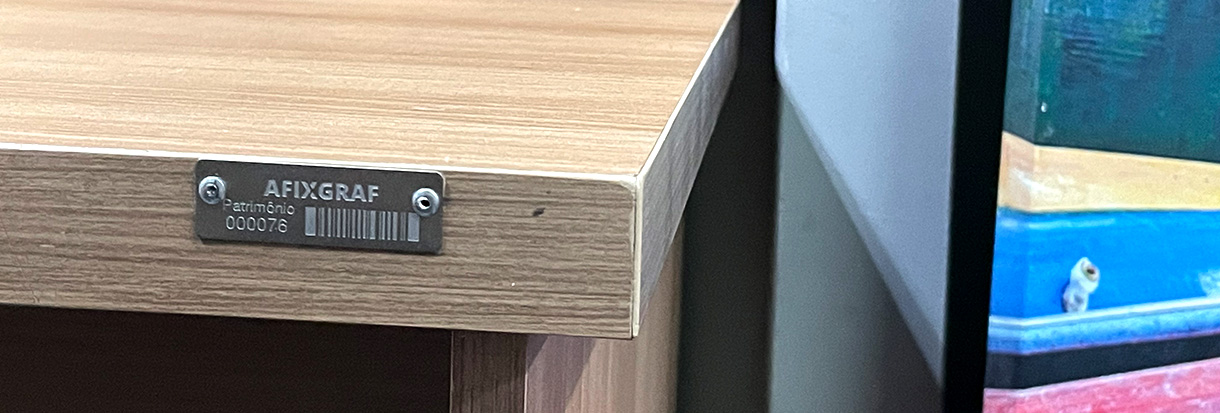 Placa de aço inox gravada para identificação patrimonial com rebites.